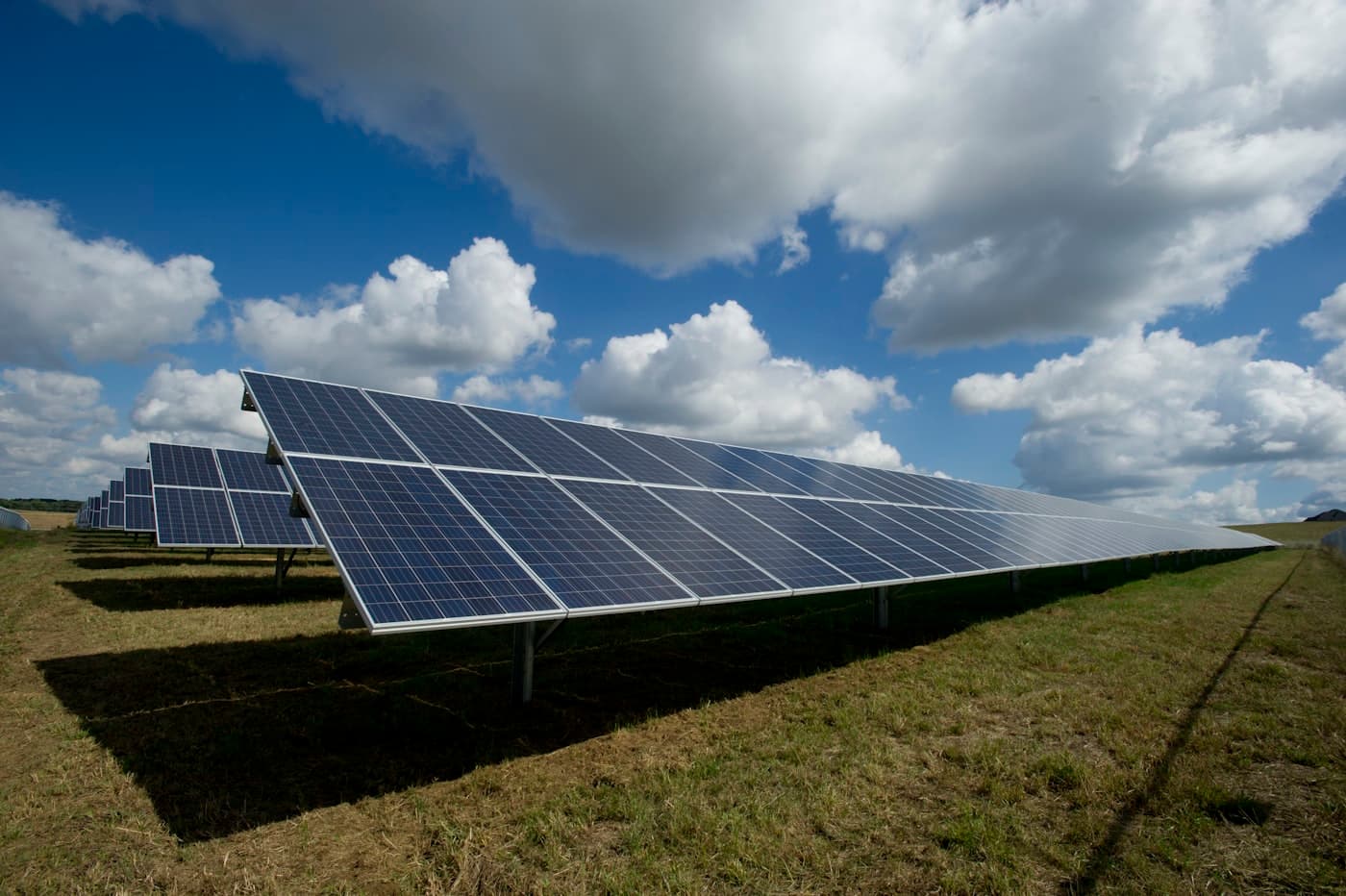 Solcelleanlæg på en mark under en skyet himmel
